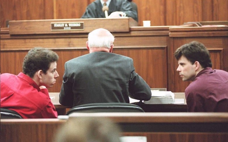 A file photo from February 1995 shows brothers Erik (at left) and Lyle (at right) Menendez talking inside a Los Angeles courtroom.