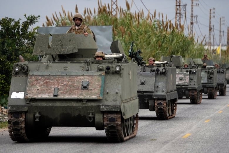 Members of Lebanon's armed forces drive in a convoy in Mansouri, Lebanon, en route to the country's southern region on Wednesday, Nov. 27, 2024.