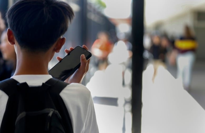 Shot from behind of a student holding a cell phone