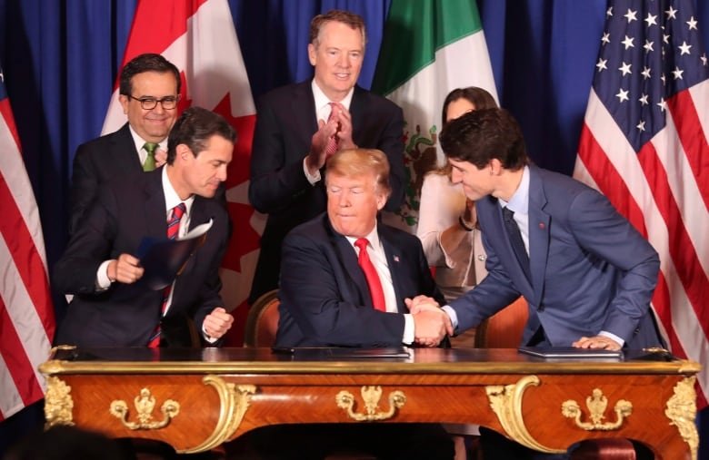 Donald Trump, center, shakes hands with Canada's Prime Minister Justin Trudeau as Mexico's President Enrique Pena Nieto looks on after they signed a new United States-Mexico-Canada Agreement