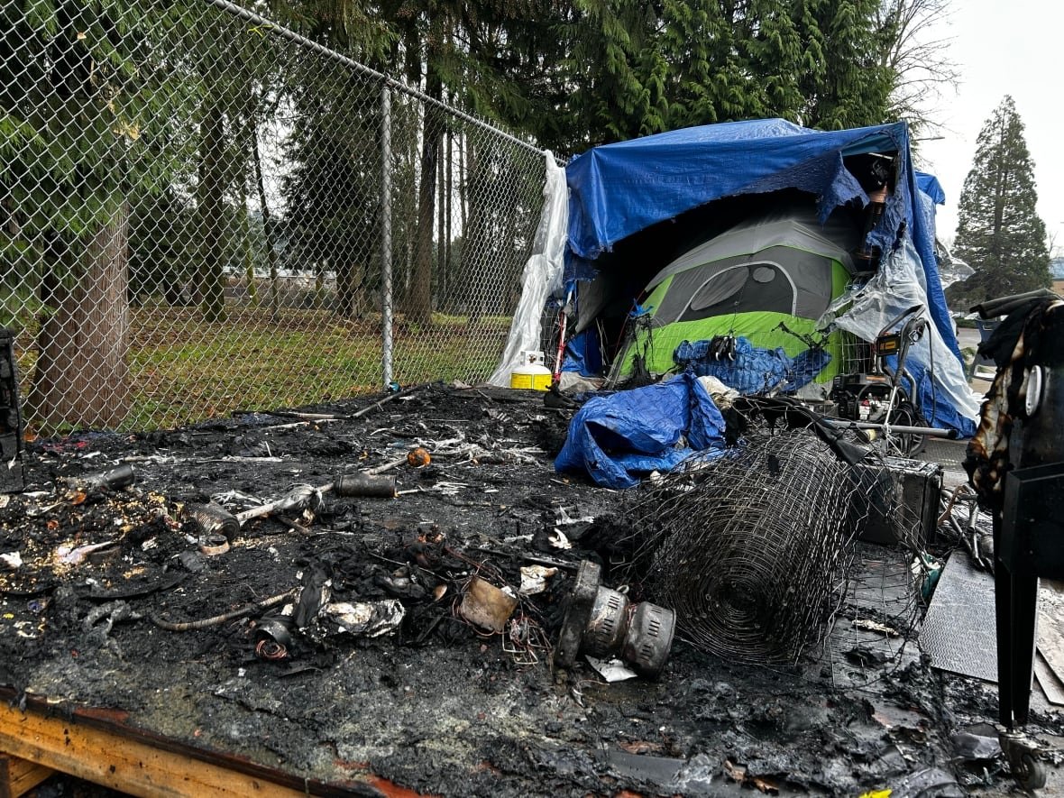 Charred remains of a tent and wooden platform.