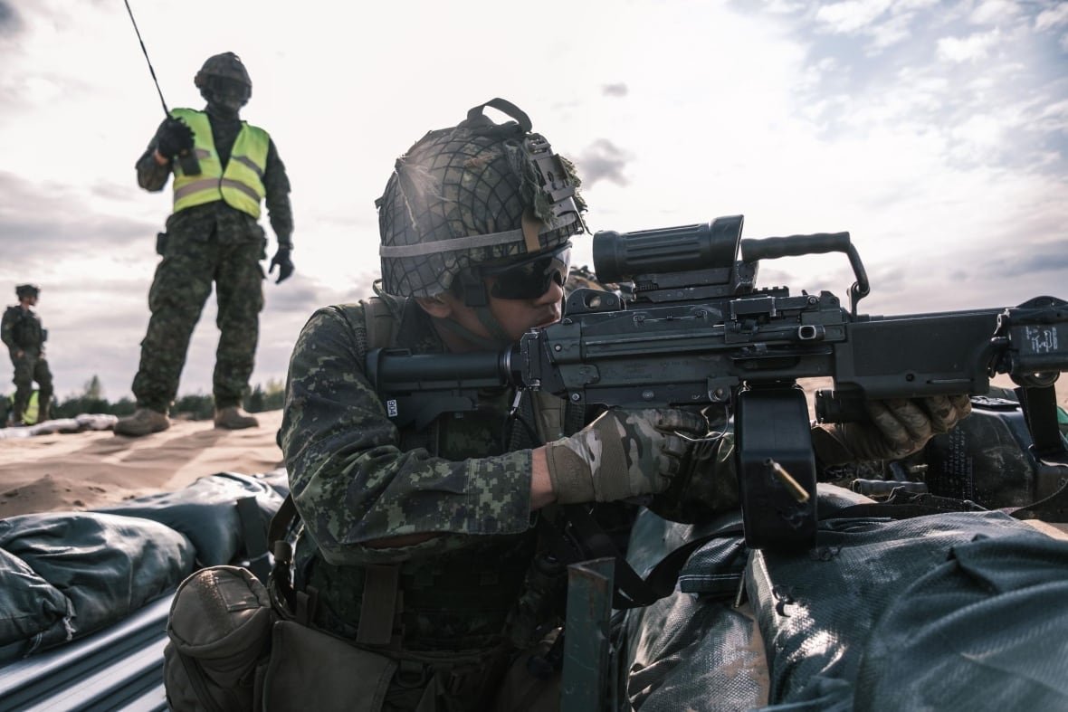 canadian-troops-latvia-exercise A soldier fires a machine gun.