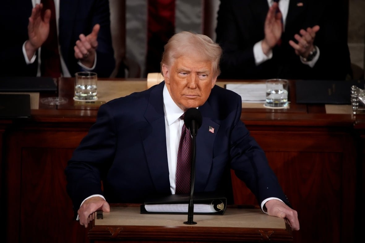 donald-trump-1 A man in a suit stands at a podium