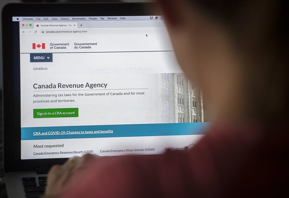 cyberattack-cra-account-20200816 A person looks at a Canada Revenue Agency homepage on a web browser.