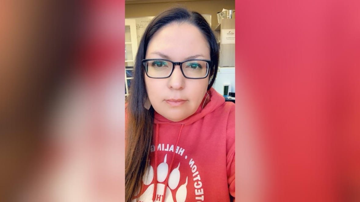 francine-mckenzie A close-up of a person with glasses and long hair, who is wearing a red hoodie.