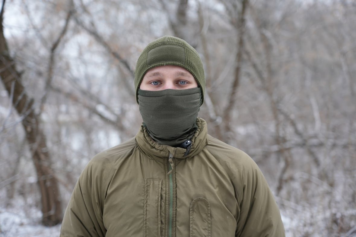google A soldier with blue eyes and a mask covering the lower half of his face looks at the camera.