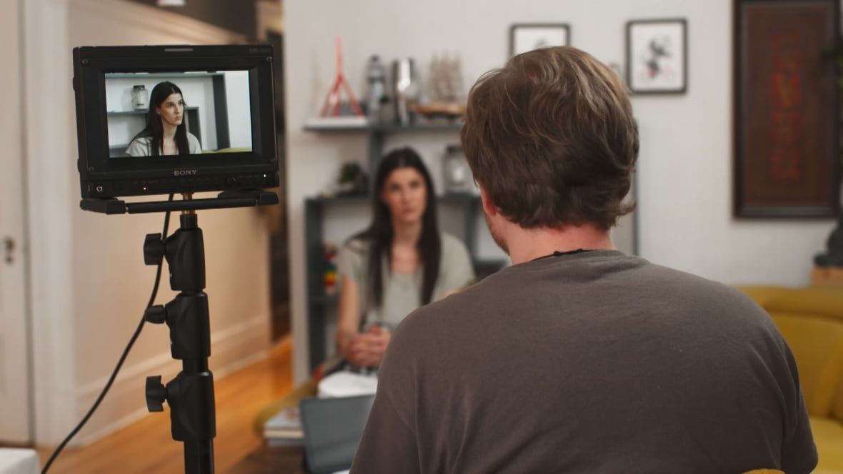interview A person with their back to the camera speaks to another person.