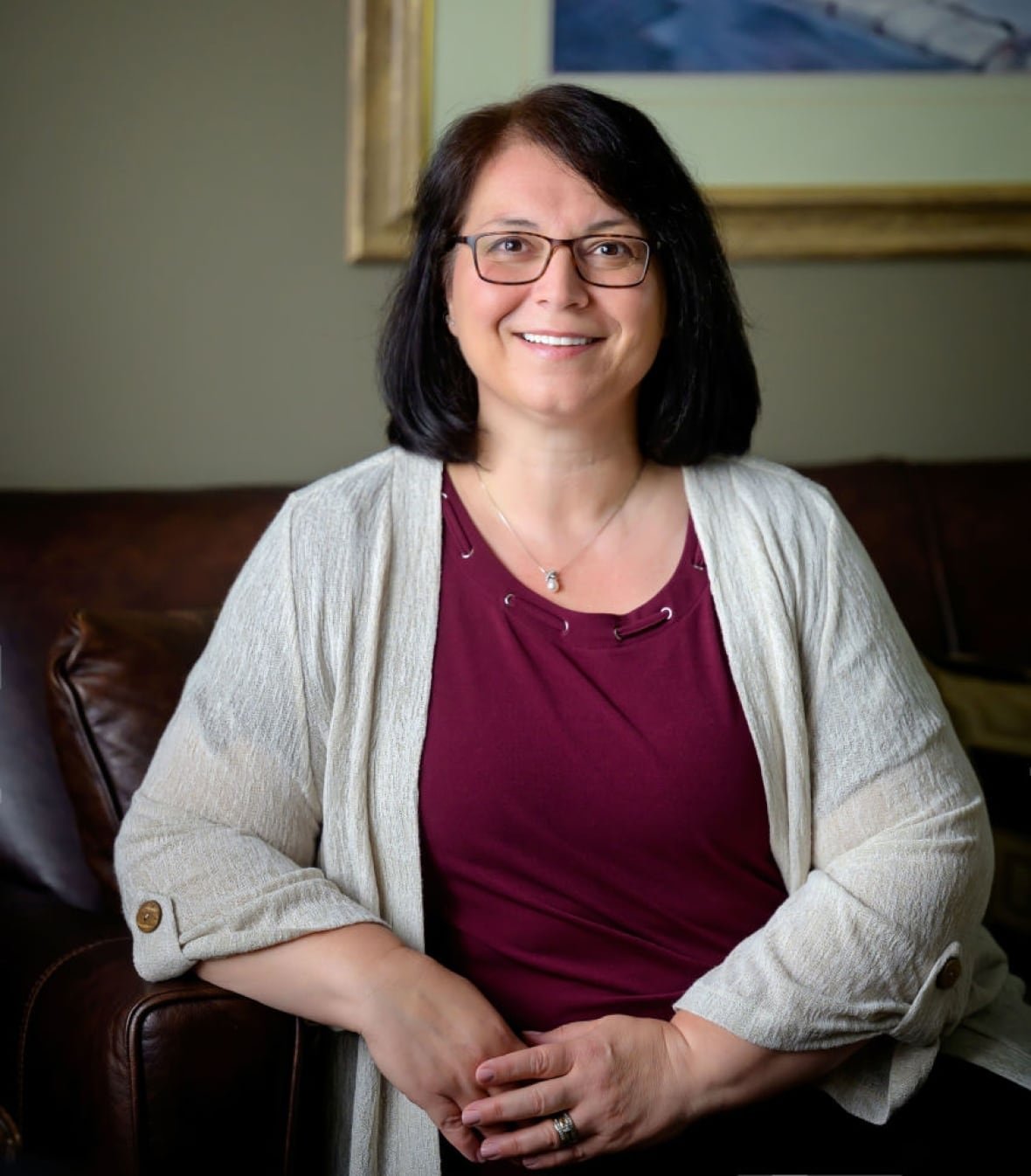lisa-votta-bleeker A smiling woman seated on a leather sofa
