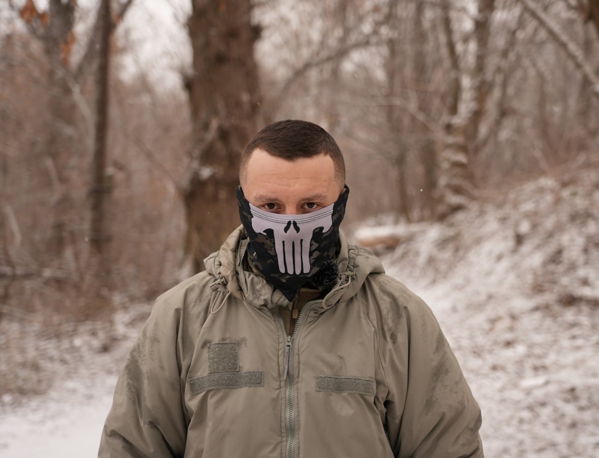 yaryi Man with mask covering half of his face looks at camera.