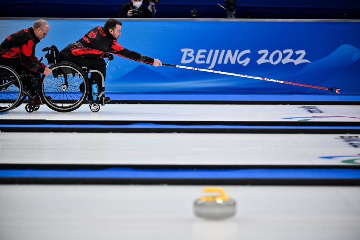 1239066419 A wheelchair curler throws a rock.