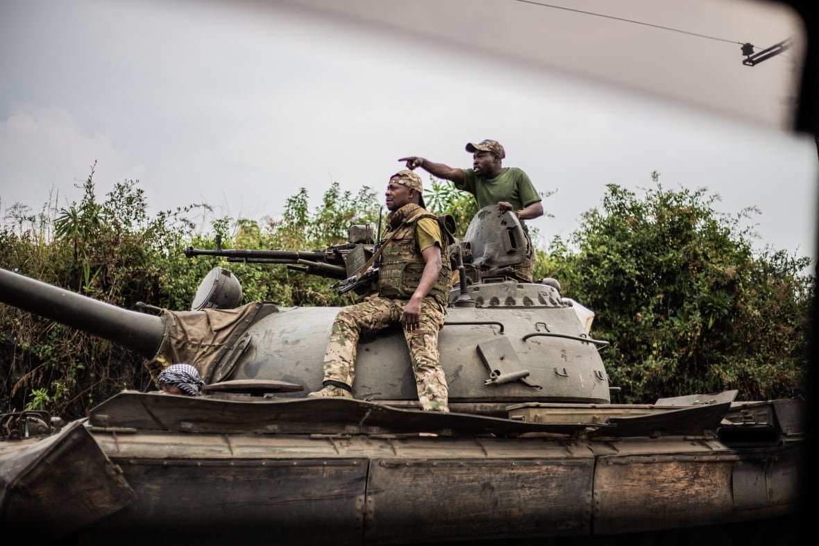 2194840859 Soldiers ride atop a tank.