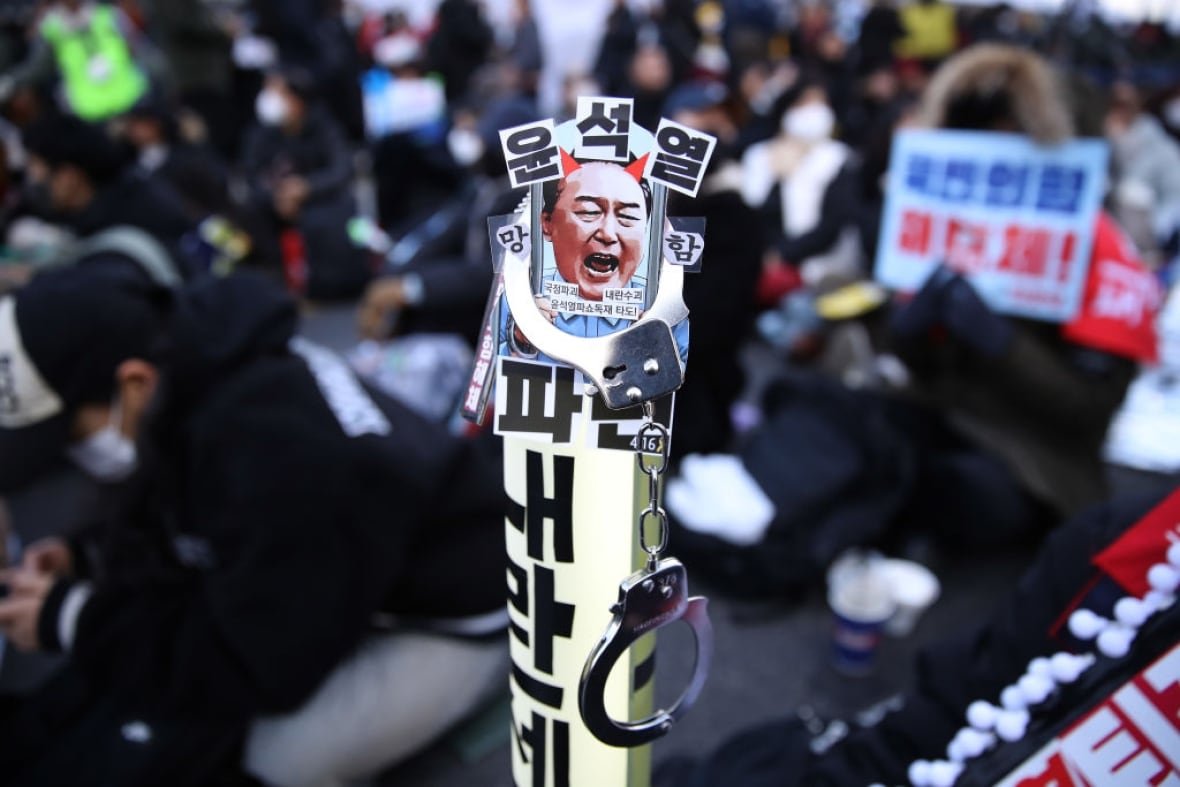 2195838359 A protest sign with the face of suspended South Korean president Yoon Suk Yeol.
