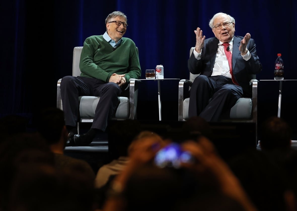 94238818 Bill Gates and Warren Buffett sit in chairs on a stage.