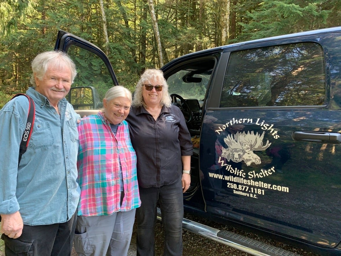angelika-langen-merrilee-prior Three older people pose for a picture near a black pickup truck.