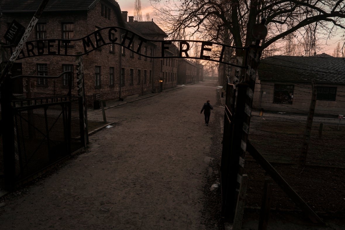 aptopix-poland-auschwitz-80th-anniversary-1 A person walks under a set of iron gates