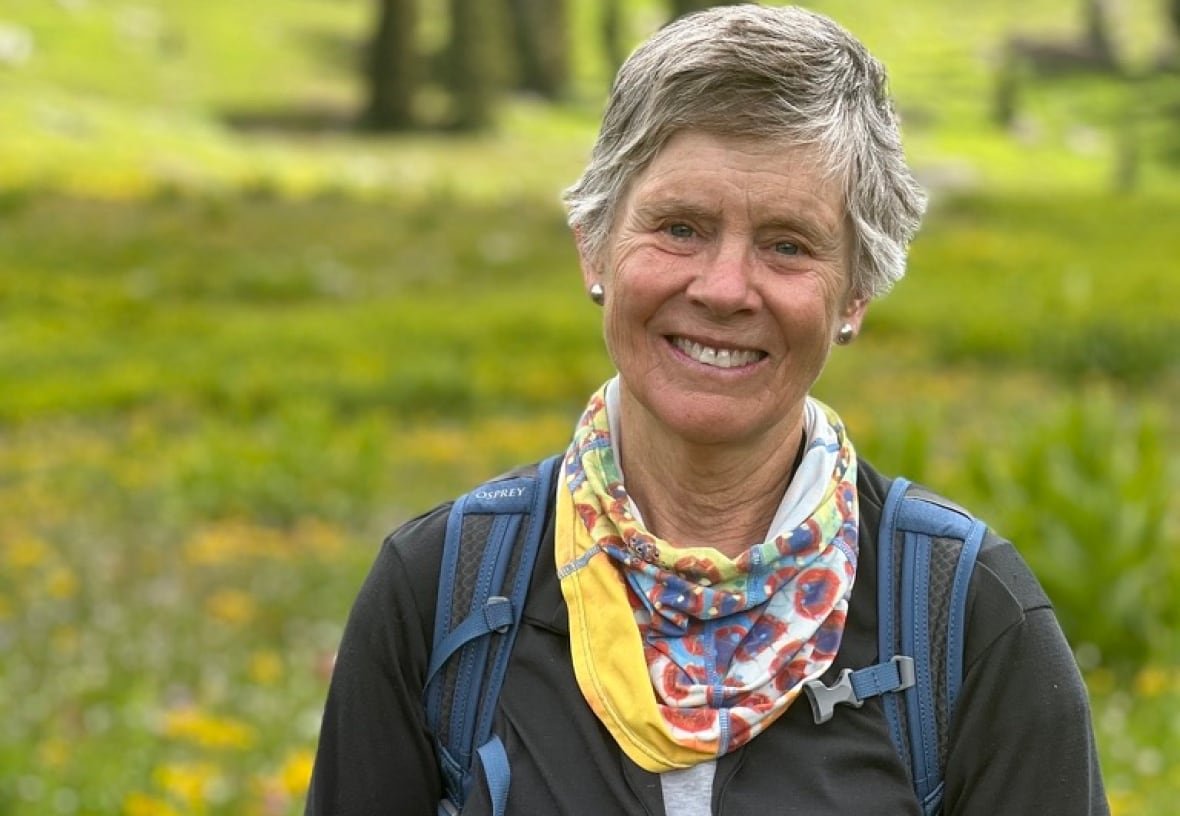 cathy-whitlock A woman stands in a field.