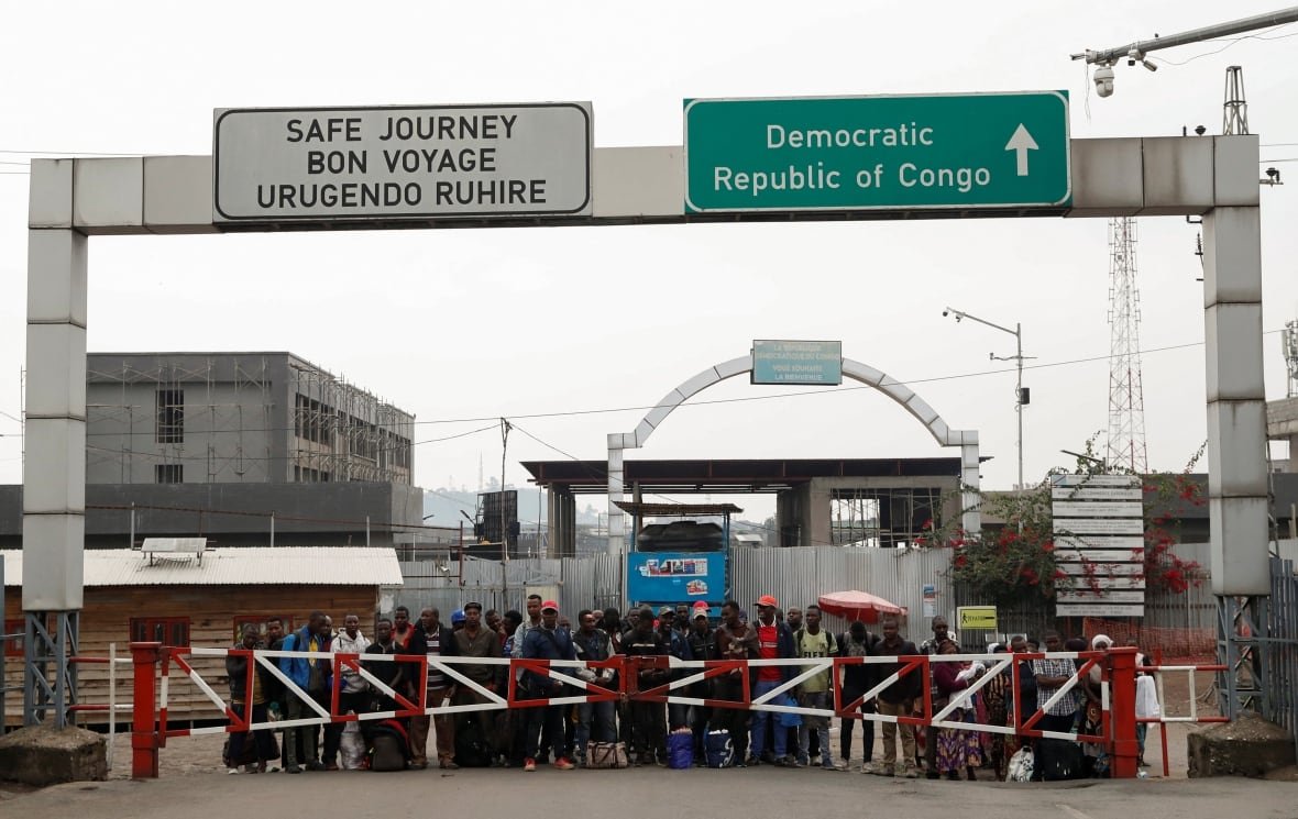 congo-security-2 United Nations truck drivers and Congolese civilians stand behind crossing.