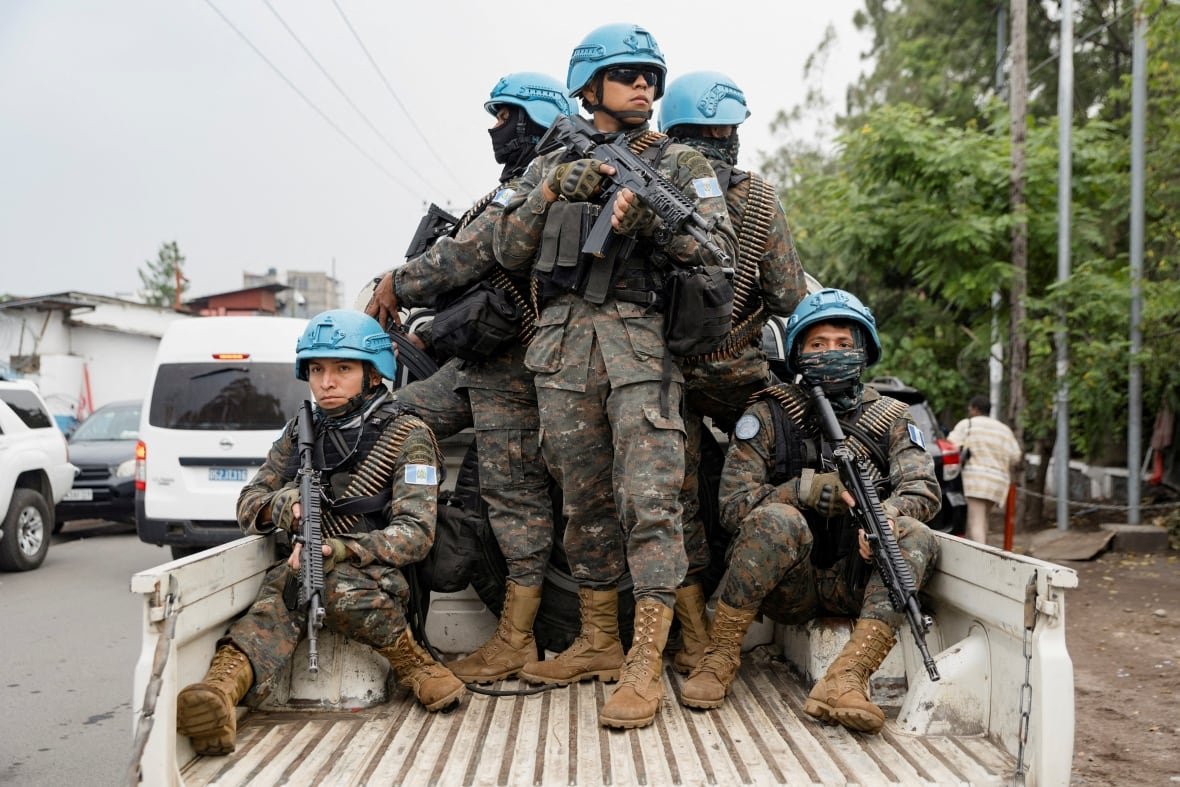 congo-security Armed soldiers ride in the back of a pickup truck.