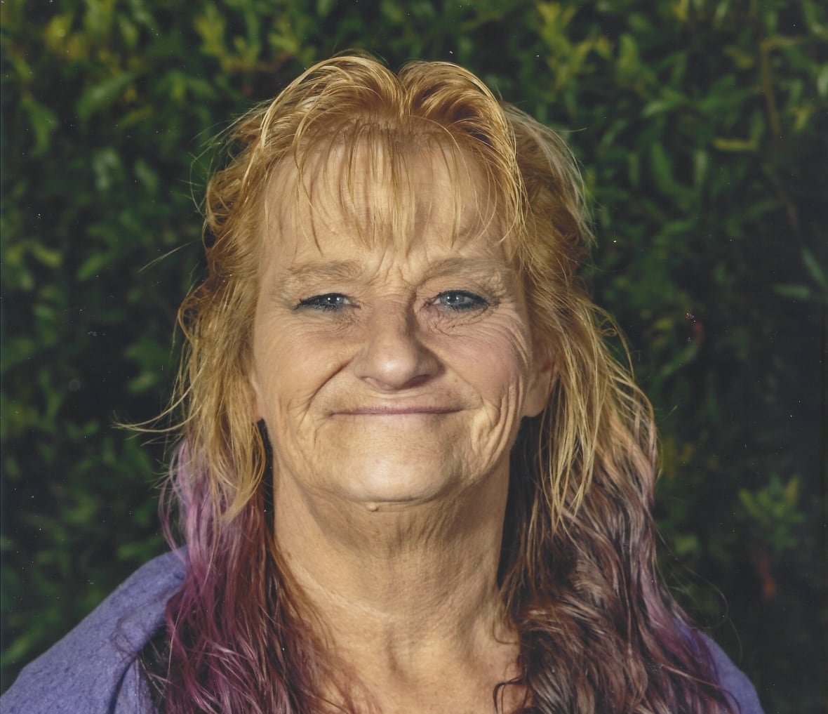 diane-chandler An older woman with long, curly hair smiles for the camera.