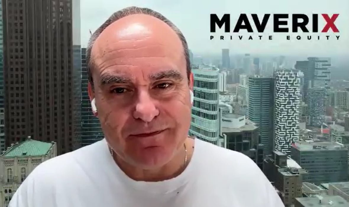 john-ruffolo John Ruffolo sits in front of a green-screened cityscape.
