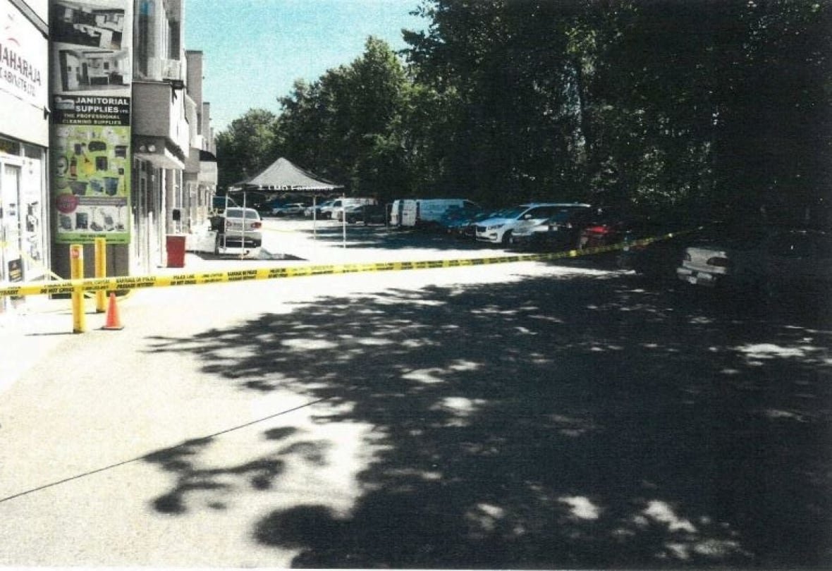 malik-crime-scene Police tape is up near businesses and trees.