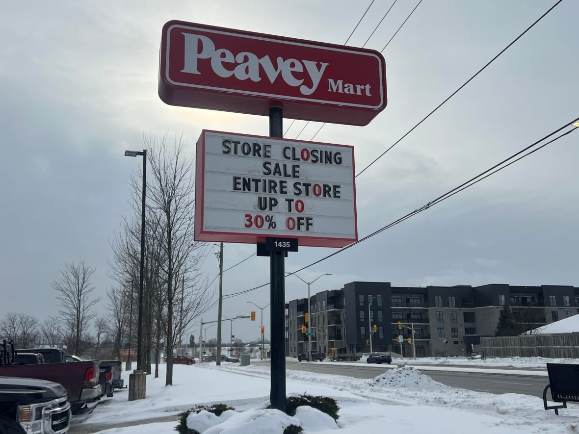 store-closing-1 A tall red sign on a snow-covered street reads Peavey Mart. And below it on a rectangular white sign, 'Store closing sale. Entire store up to 30% off.'