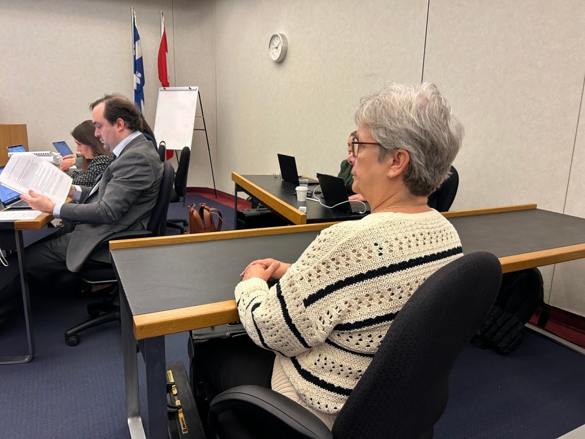sylvie-brosseau-1 A woman with grey hair and glasses sis seen sitting at a table in a hearing room at the Montreal courthouse.