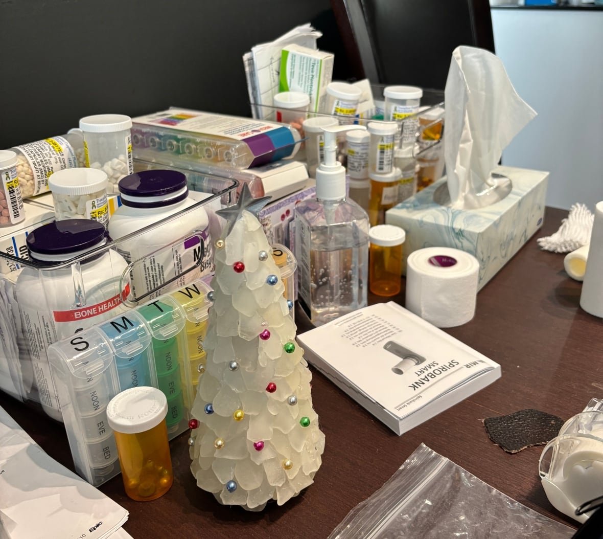transplant-medications Bottles of medications fill a small table in a room.