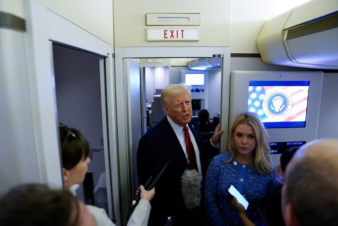 usa-trump-2 A person speaks to reporters inside an airplane.