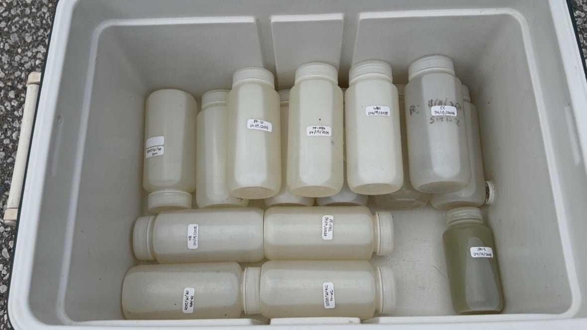 water-samples-collected-uwindsor Bottles with labels and water sit inside a bin.