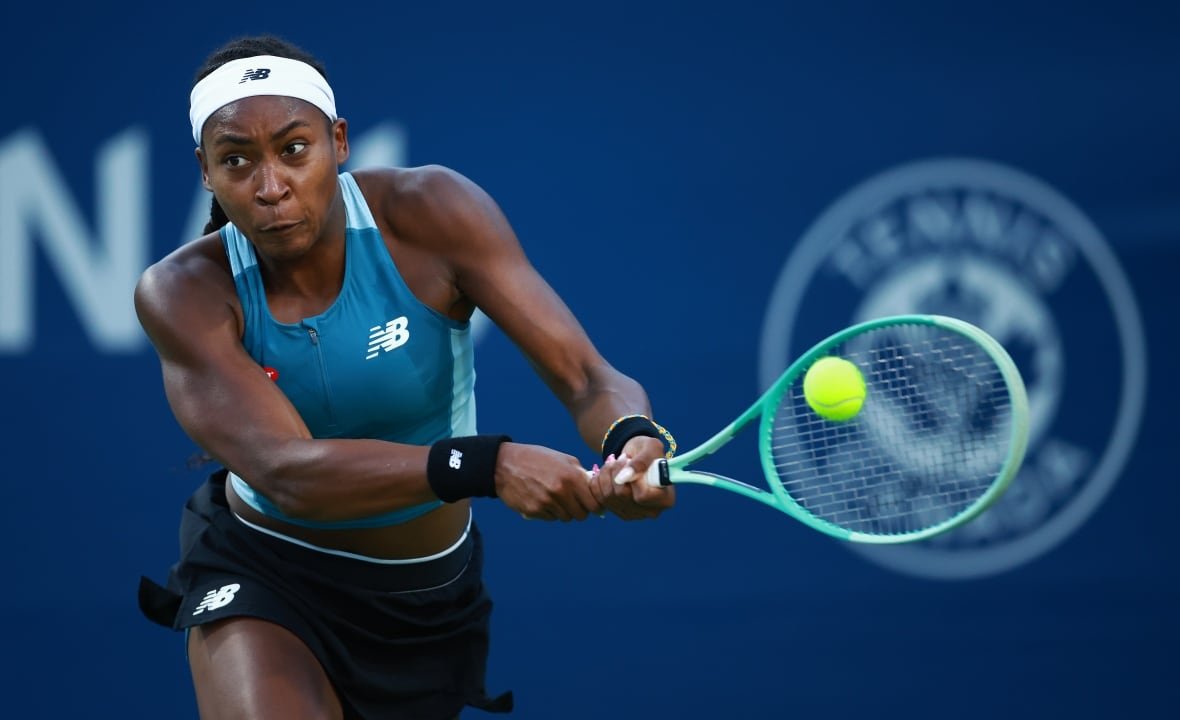 2165584530 A female tennis player takes a backhanded swing.