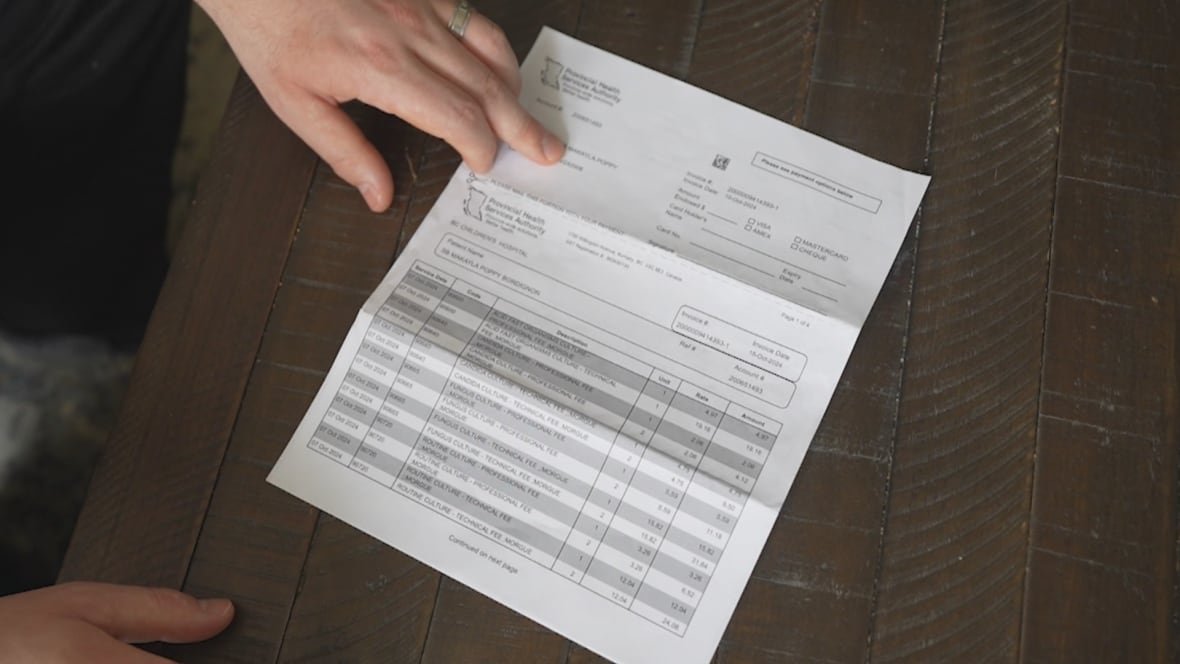 autopsy-bill A man's hand shows an invoice from the Provincial Health Services Authority