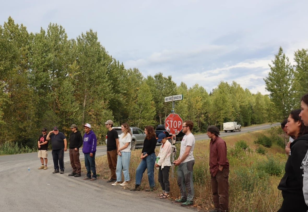 blockade-aug-22 People stand in a row on a road.