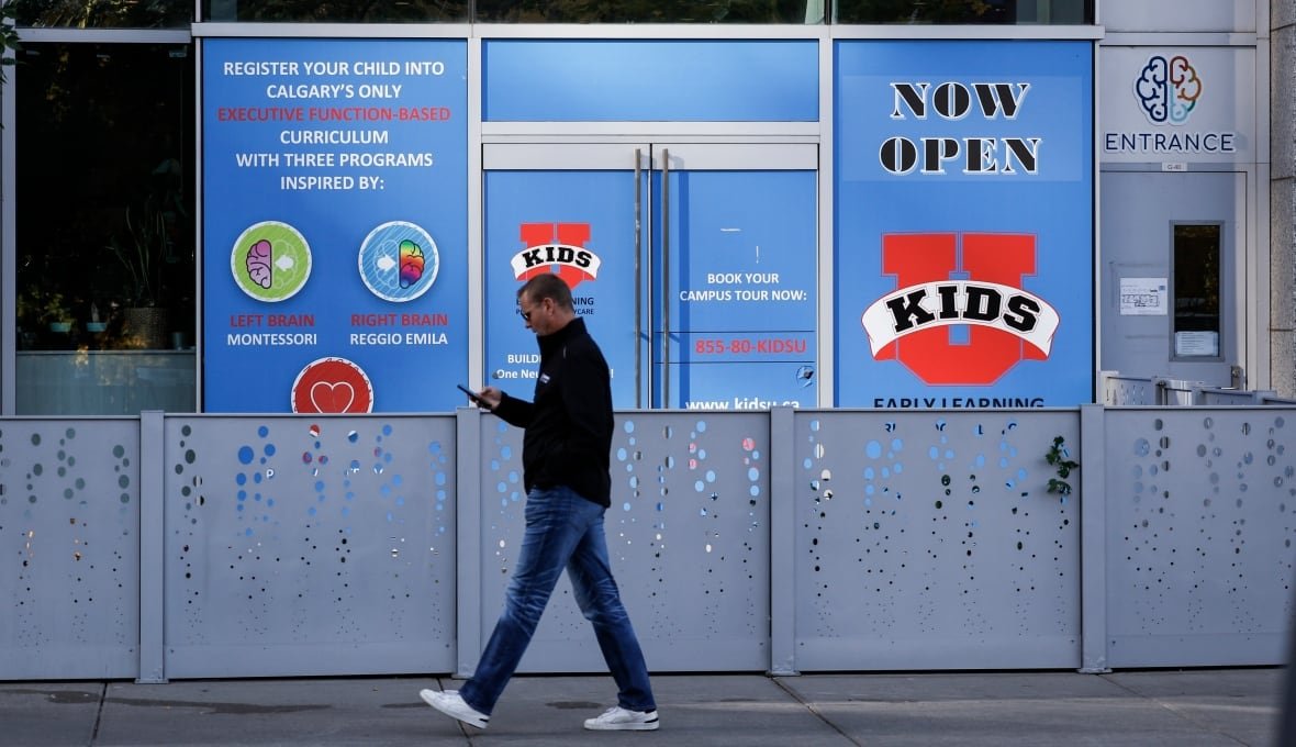 calgary-e-coli-inspections-20230922 A man walks in front of a daycare storefront.