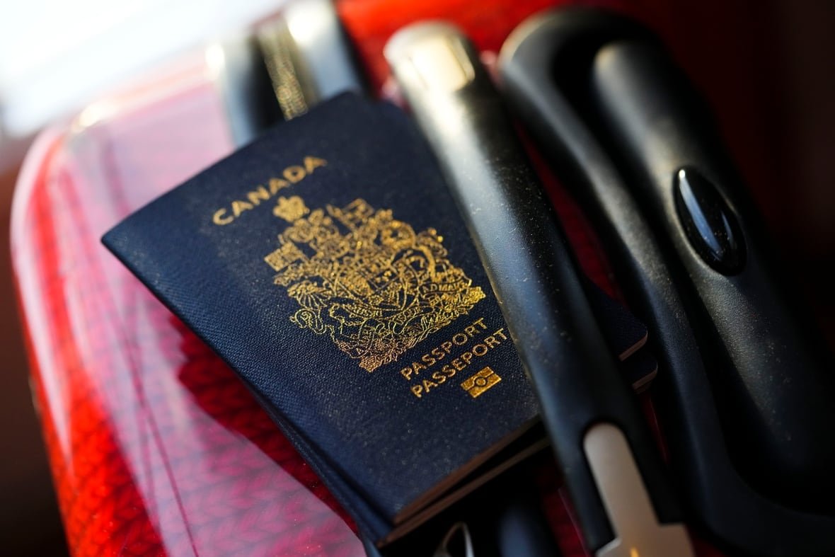 canada-passport-travel-border A Canadian passport on a red suitcase.