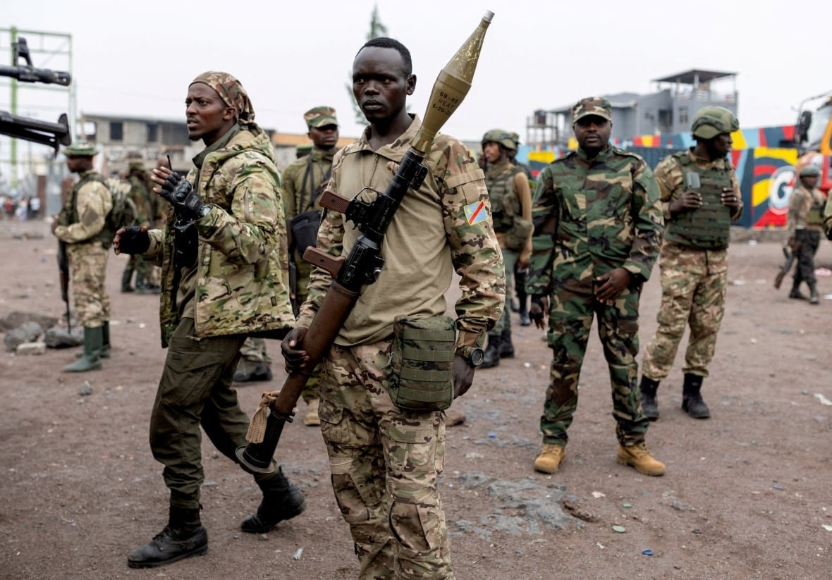 Armed fighters are seen gathered at a compound.