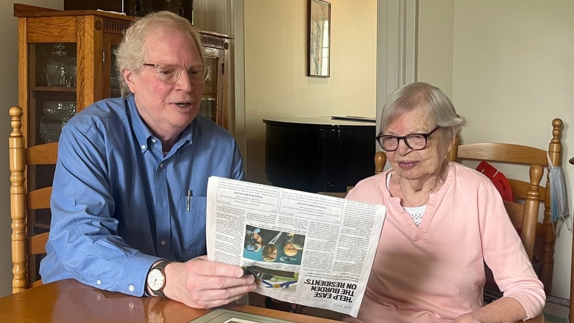 dorothy-lamont-1 A man and an elderly woman sit and look at a newspaper