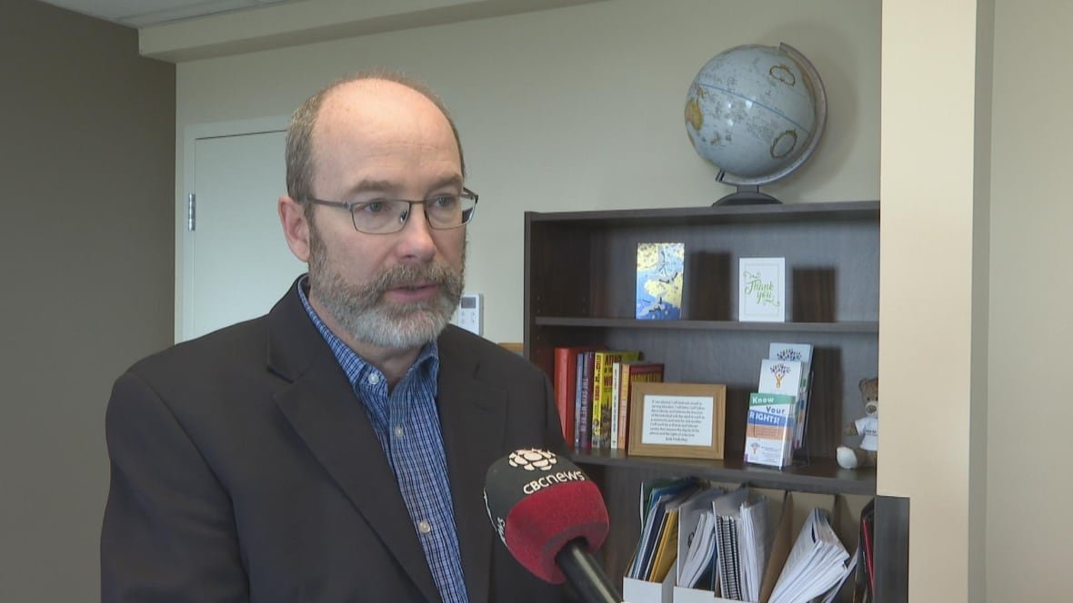 green-party-mla-matt-macfarlane Man with glasses stand for an interview inside of an office. He is wearing a blazer and dress shirt.