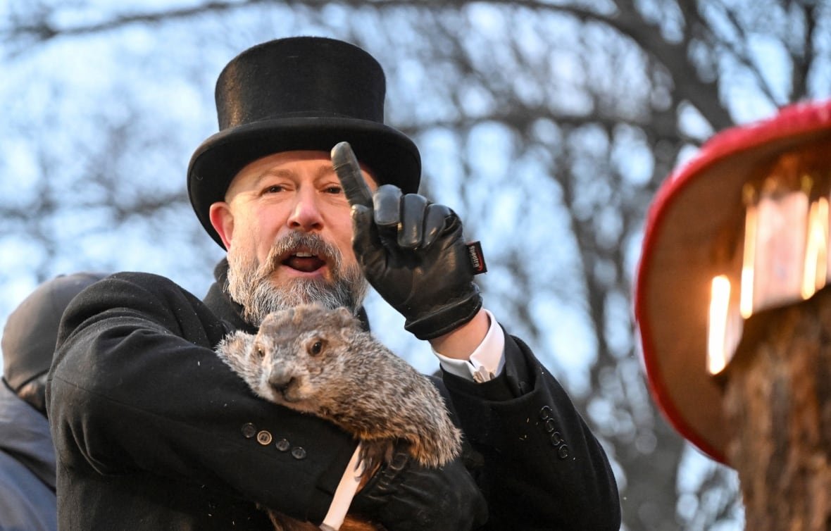 groundhog-day A man in a tophat holds a groundhod.