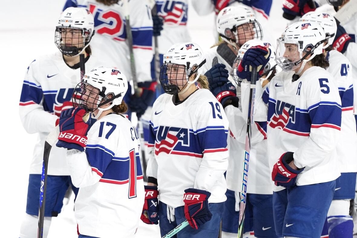 hkw-rivalry-series-20250208-1 A group of female players wearing white Team USA jerseys look on from the ice.