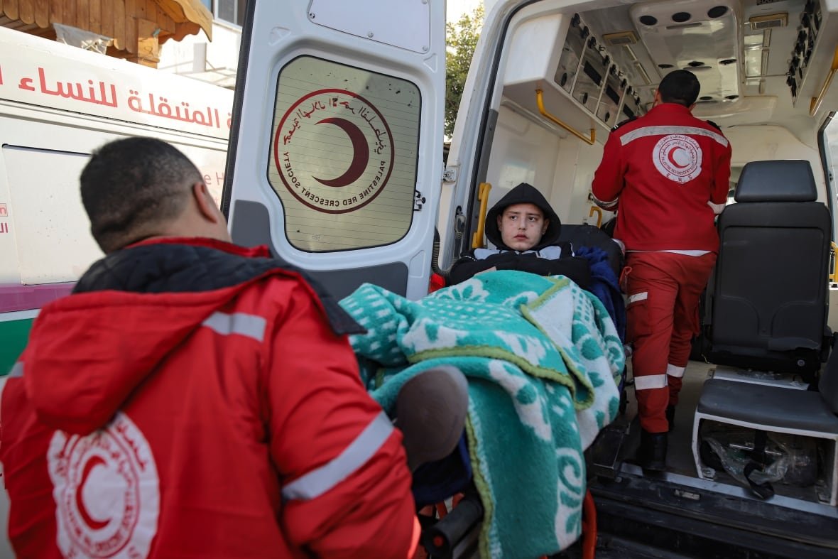 A girl is carried into an ambulance.