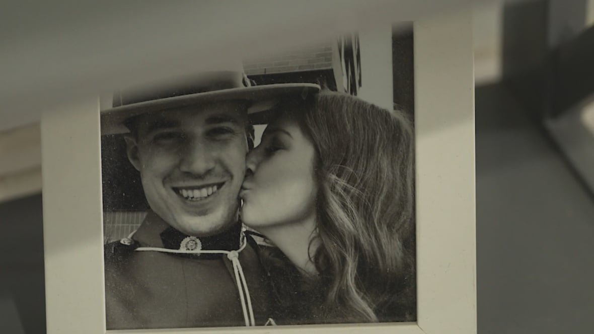 laura-and-nick-bordignon A woman with long hair kisses the cheek of a man in a Mountie hat.