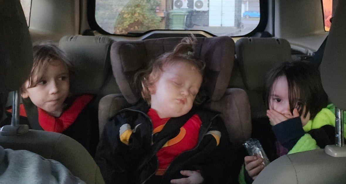maggie-campbell-sons Three kids are seen in the backseat of a car.