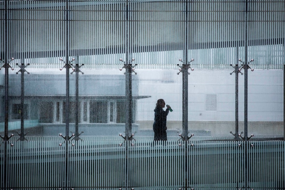 school-daily-life A silhouetted person walks in a hallway.