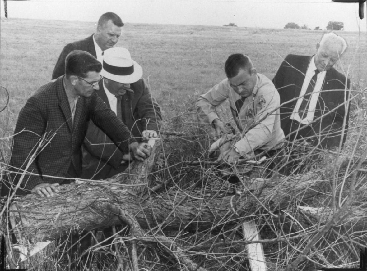 sharon-kinne-jones-site Five mean looking at some brush in a field.