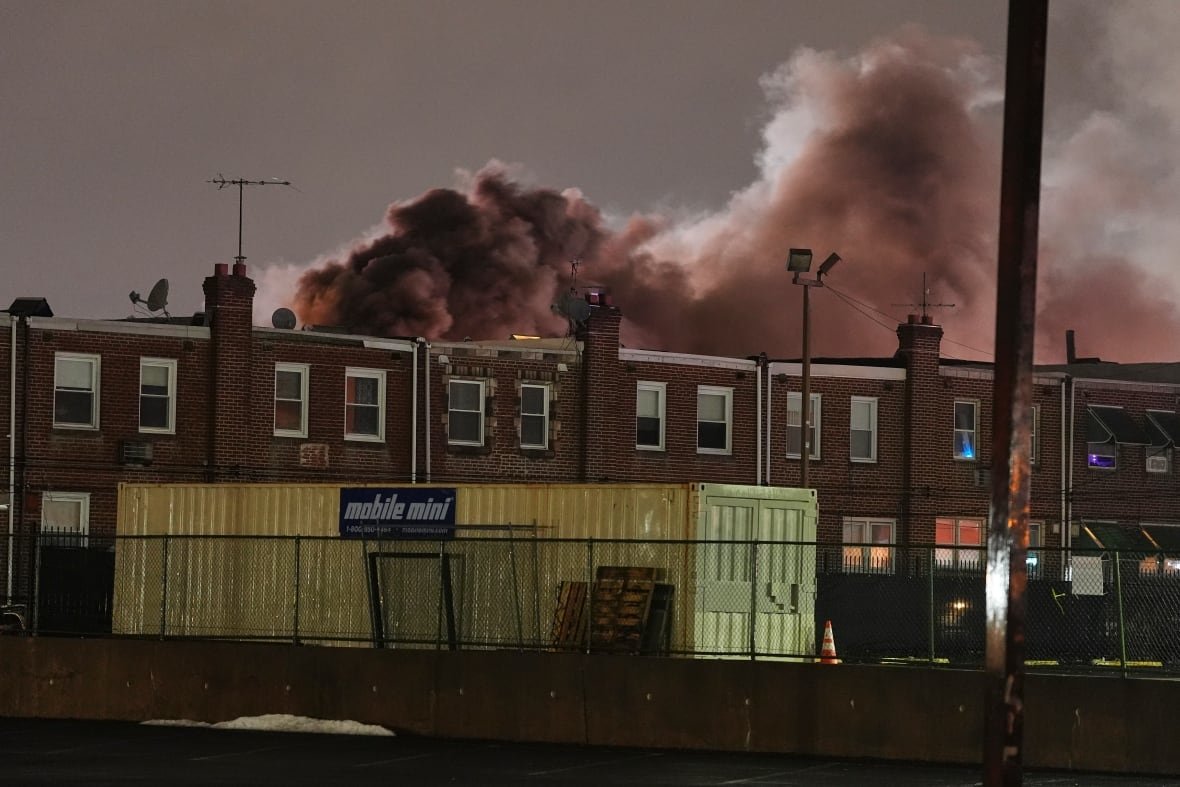 Smoke rises above a set of row houses in Philadelphia in the aftermath of a plane crash.