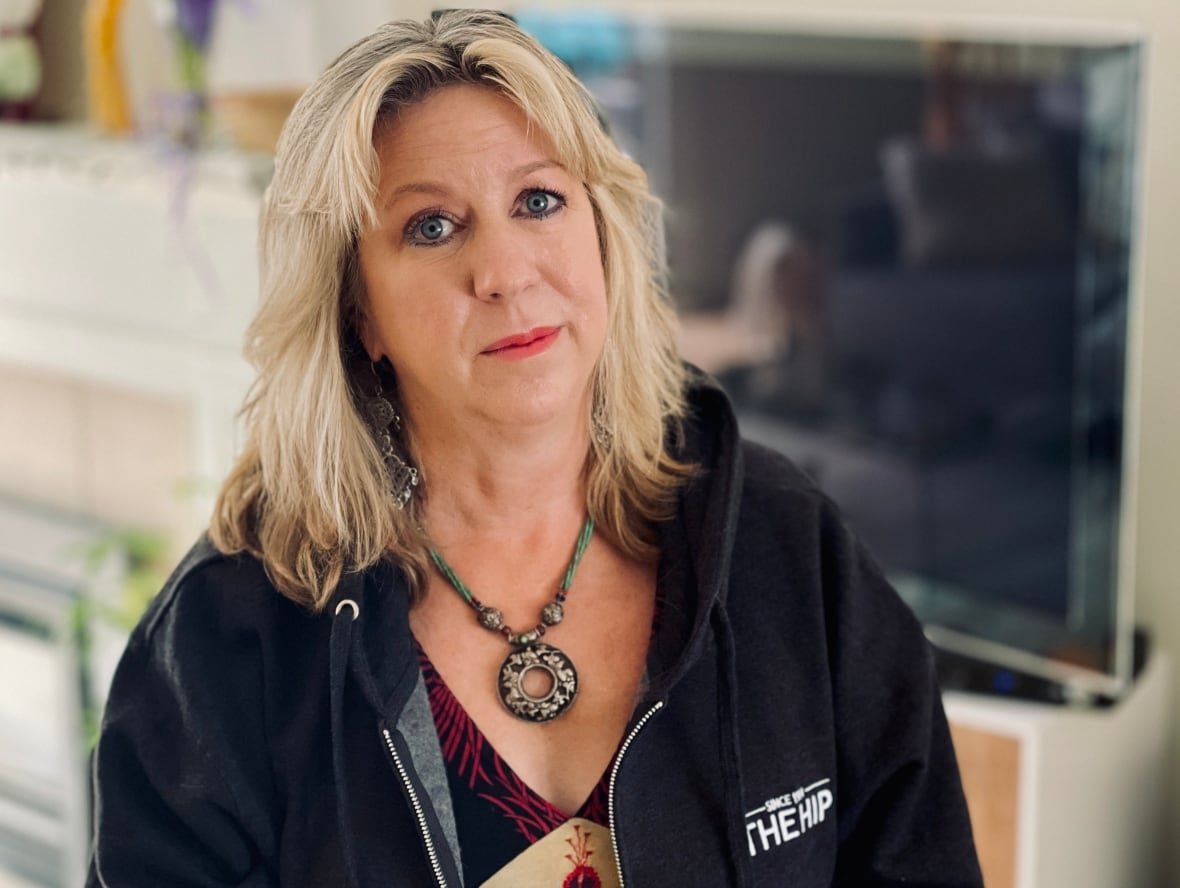 stefanie-strathdee-1 A woman with blond, shoulder length hair wearing a circular pendant and Hip sweater.