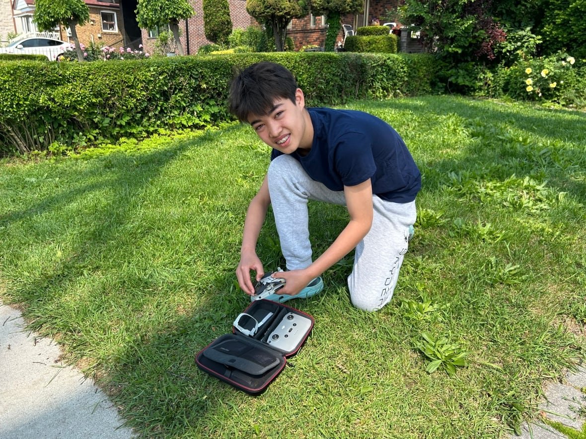 Ethan Tantram, 13, readies his drone to explore the old elm's upper reaches. Ethan says the tree has been a neighbourhood landmark for his entire life.