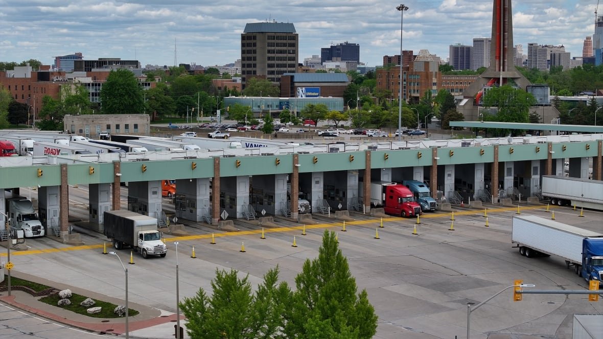 Trucks drive across the border from Detroit back into Canada.