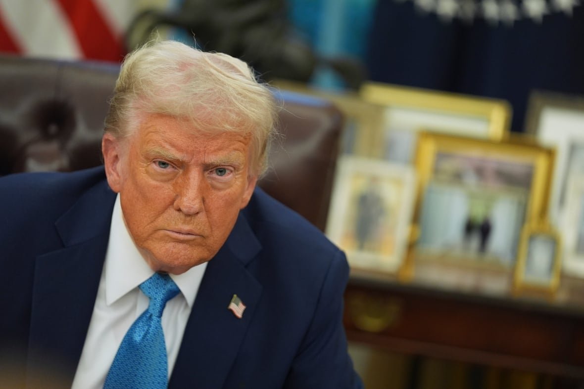 trump-1 A man in a suit looks at the camera.